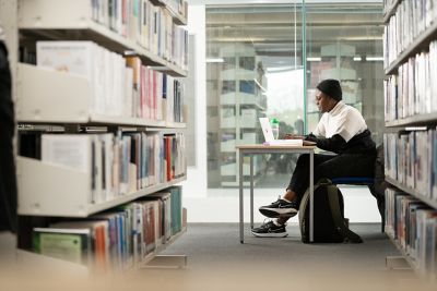 Student studying at study space with laptop in Business Library