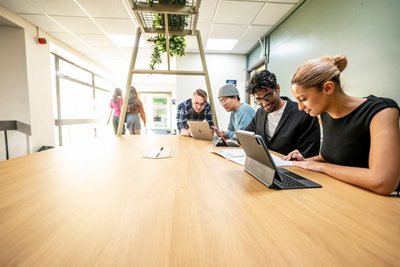 Postgraduate students in a group study session at a table in the Sir Clive Granger Building
