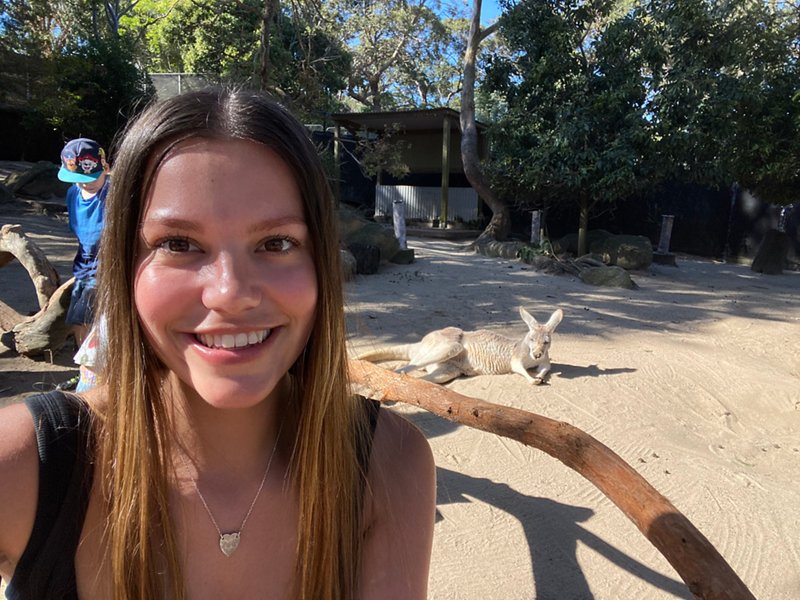 A female law student poses with a Kangaroo whilst studying abroad in Australia