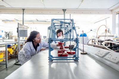 Undergraduate students adding weights to a Pasco bridge loading demo. L2-122, Geotechnics research laboratory