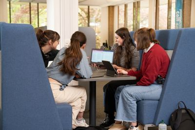 Students working together in a group study booth in Hallward Library. From left to right: Agnieszka Sokolowska, Liberty Lee, Hannah Parker, Emily Trappen.
