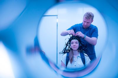 Being attached by Professor matthew Brookes, female PhD student Molly Rea wearing a MEG system that can be worn like a helmet, allowing free and natural movement during scanning October 2019. Photography by Lisa Gilligan-Lee.Copyright belongs to the University of Nottingham.https://www.nottingham.ac.uk/research/beacons-of-excellence/precision-imaging/our-projects/meg/meg.aspx