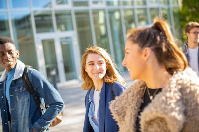 Undergraduate students walking in front of the Monica Partridge Building, University Park