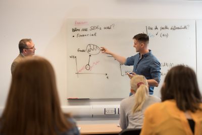 Academic and student giving a Mathematics seminar. May 2019 by Simon Litherland.