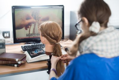 Member of staff practicing roman hairstyles