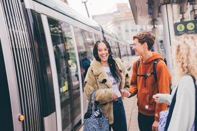 Undergraduate students waiting for a tram in the Old Market Square, Nottingham City Centre - November 2021.Lily Pearce (braids); Emily Hay (orange hoodie) and Fearne Darbyshire (curly blonde hair).