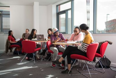 Harshad Manavalan - Indian; Princess Abumere - Nigerian and Leonie Royes - British sitting with other postgraduates inside the Institute for Mental Health, Jubilee Campus.