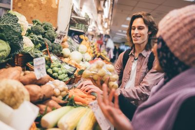 Undergraduate students shopping for fruit and vegetables in the Victoria market, Nottingham City Centre - November 2021.Mariam Abedraba Abdalla (pink hat) and Dominic Beale (check shirt)