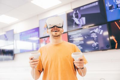 Undergradute student using a virtual reality headset in the Product Design Studio infront of screens