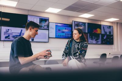 An undergraduate student shows her design to a fellow student