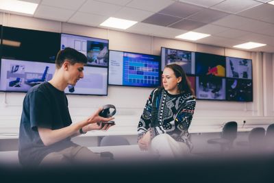 An undergraduate student shows her design to a fellow student Jake Woolard