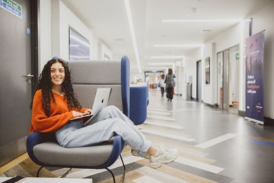 Undergraduate student working on laptop in Lower Ground Floor of Portland Building
