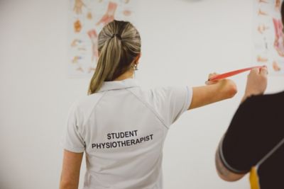 Undergraduate students practice stretches with a resistance band in the Sports Injury Clinic, David Ross Sports Village