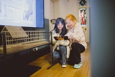 Pair of undergraduate students using a tablet next to a 3D architecture model in Lenton Firs