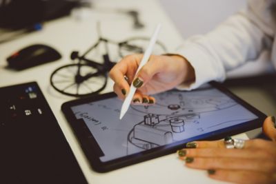 A student working on a design drawing on their tablet in our product design studio