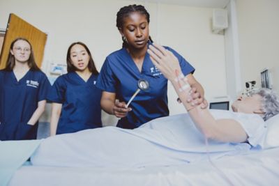 Students practicing reflex testing on a manikin in Queen's Medical Centre Medical School, University Park
