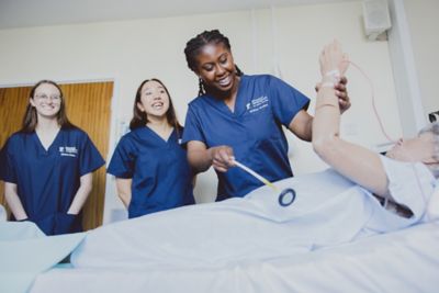 Students practicing reflex testing on a manikin in Queen's Medical Centre Medical School, University Park