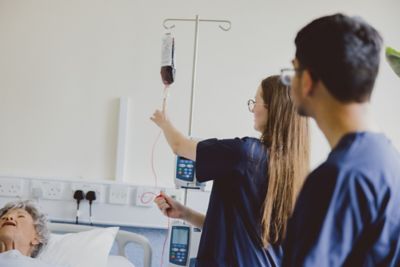 Student adjusting an IV drip on a manikin, Clinical Skills room D1035, Queen's Medical Centre Medical School, University Park