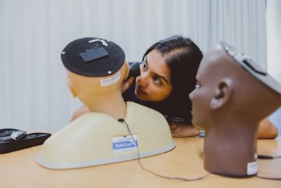 Student using otoscope on digital ear examination trainer, University Park