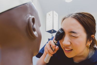 Student using opthalmoscope on dark-skinned digital eye examination/retinopathy trainer, University Park