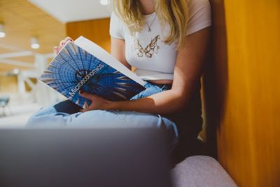 Undergraduate student reading an economics textbook, Monica Partridge building