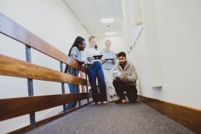 Undergraduate students playing with a smart robot outside the Law Tech lab, Law and Social Sciences Building