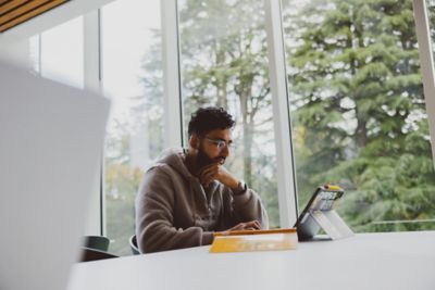 Undergraduate student using a tablet in the Monica Partridge building, University Park campus