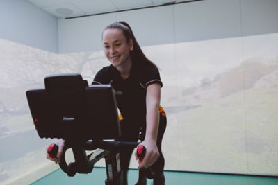 Undergraduate student on a Wattbike in the Immersive Suite