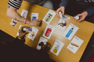 Undergraduate students interacting with fats and sugar content samples and cards