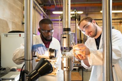 Student and techician using Instron 8801 load frame, Nottingham Transportation Engineering Centre