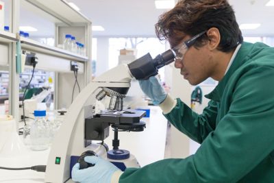 Undergraduate biosciences student looking into a microscope in the super lab