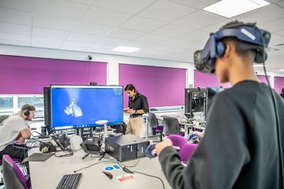 Undergraduate student building a formula student car using a VR headset in Pope Building CO1, EEE Collaborative Teaching and Project Lab 2