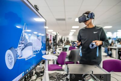 Undergraduate student building a formula student car using a VR headset in Pope Building CO1, EEE Collaborative Teaching and Project Lab 2