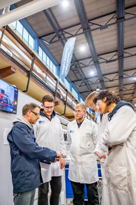 University staff member showing students plans for designs to be created in the Swift Cut machine