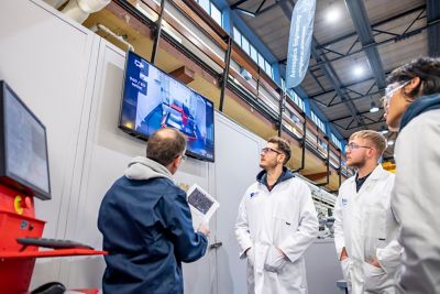 University staff member showing students plans for designs to be created in the Swift Cut machine