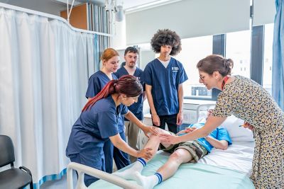 Undergraduate students performing a knee exam
